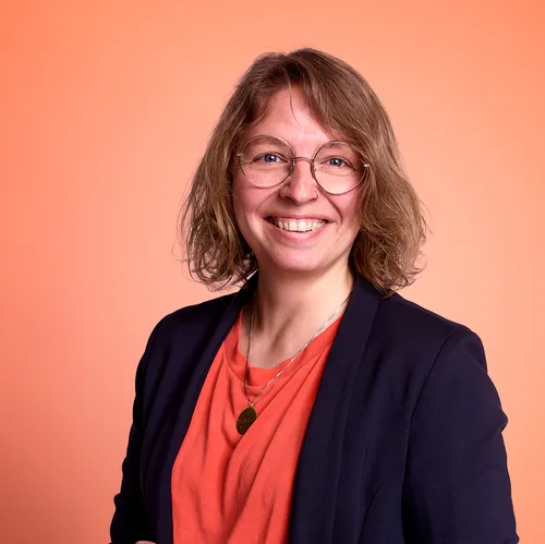 Louise smiling in a orange shirt